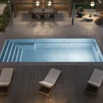 Piscine creusée en fibre de verre Mova, modèle 12x28, finition Diamant couleur Mova, ambiance soirée éclairée