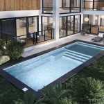 Piscine creusée en fibre de verre Mova, modèle 12x30 - Avec terrasse, finition Diamant couleur Mova, ambiance soirée éclairée