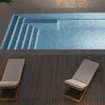 Piscine creusée en fibre de verre Mova, modèle 12x20, finition Diamant couleur Mova, ambiance soirée éclairée